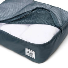 Load image into Gallery viewer, Close up to the orion blue packing cube with white clothes rolled inside.
