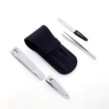 Load image into Gallery viewer, The image displays the black leather flap manicure set with the items included. One pair of hand nail clippers, one pair of toenail clippers, one pair of tweezers, and one nail file.
