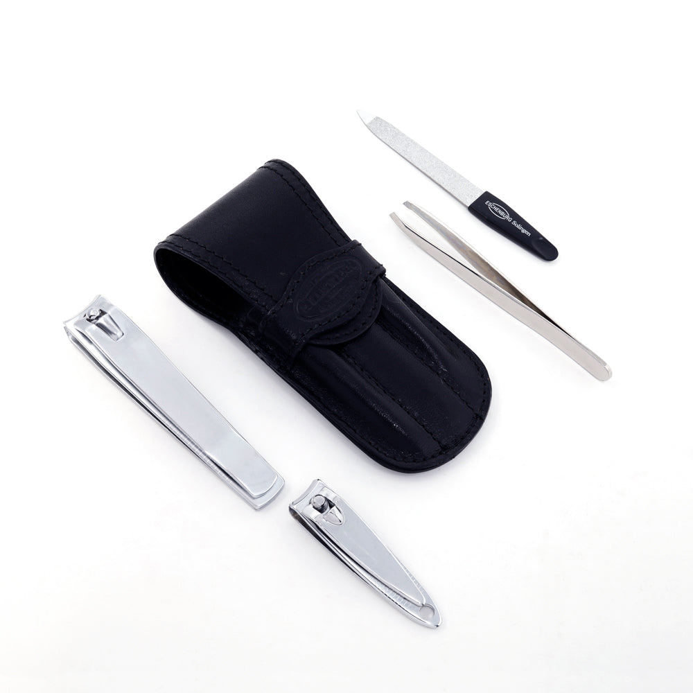 The image displays the black leather flap manicure set with the items included. One pair of hand nail clippers, one pair of toenail clippers, one pair of tweezers, and one nail file.