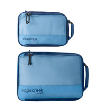 Load image into Gallery viewer, Two blue packing cubes with mesh tops and the Eagle Creek brand logo on the side.
