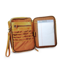 Load image into Gallery viewer, Interior view of the tan leather bag. it features organization pockets. A notepad is arranged in the right compartment.
