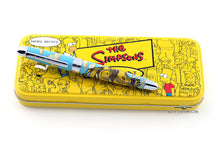 Load image into Gallery viewer, The Simpsons Acme Homer Peel pen is shown on top of the presentation box it comes in. The box is yellow, and has the Simpsons logo in the middle along with different characters outlined around it.
