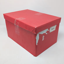Load image into Gallery viewer, Angled view of the red cardboard box for the wooden watch chest. It has a tag, tape, and tear marks on the side panel. 

