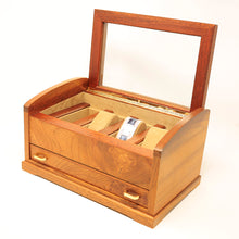 Load image into Gallery viewer, Angled front view of the wooden watch chest. The top windowed section lifts up and holds four watches, and has a drawer at the front panel. 
