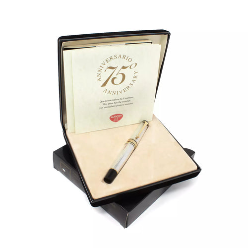 Arrangement of the black sleeve, presentation box, documents, and pen. Set on a white background.