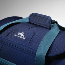 Load image into Gallery viewer, Close up of padded handle wrap and High Sierra logo on navy wheeled duffel.
