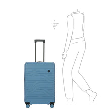 Load image into Gallery viewer, View of the suitcase with the telescopic handle pulled up. A 175 centimeter tall model is drawn next to it. The top of the handle reaches slightly under their elbow.
