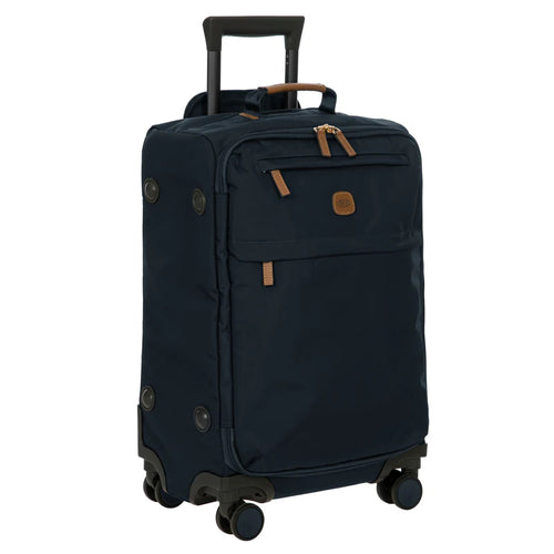 Front angled view of the suitcase on a white background. It is black with tan-leather accents on the zippers, handle, and Bric's logo.
