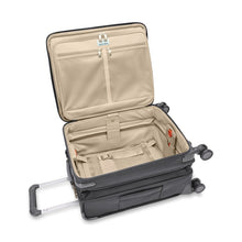 Load image into Gallery viewer, The suitcase laid on its back with the main compartment unzipped. The expandable feature is extended.
