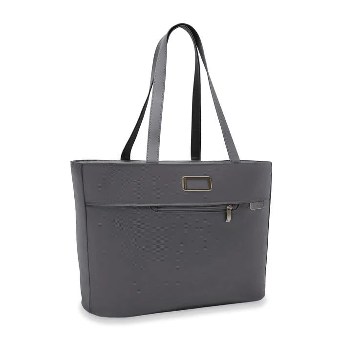 Angled front view of the steel gray tote bag. This side features a zipper compartment, a leather monogram patch, and a small Briggs and Riley logo. 