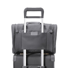 Load image into Gallery viewer, View of the back Panel attachment feature, which allows the duffle to slide over the telescoping handle of most suitcases.
