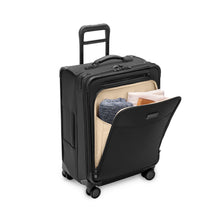 Load image into Gallery viewer, Angled view of the black suitcase with the front panel unzipped and filled with travel accessories.
