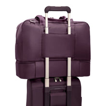 Load image into Gallery viewer, Angled back panel view of the purple weekender tote bag. The strap attaches it to the extended handle on a suitcase.
