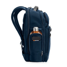 Load image into Gallery viewer, Side panel view of the navy blue backpack with a water bottle tucked into a compartment. 
