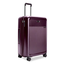 Load image into Gallery viewer, Front Angled View of the plum-colored hard shell suitcase. it has a ridged front panel, and the telescoping handle is partly extended.

