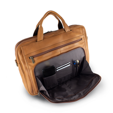Load image into Gallery viewer, Angled top view of the tan leather briefcase. The front compartment is unzipped, a cellphone, credit card, and three pens are organized in the pockets.
