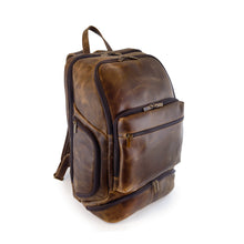 Load image into Gallery viewer, An angled full view of the brown distressed leather backpack is shown. The featured organizational zipper-closed pockets can be observed.
