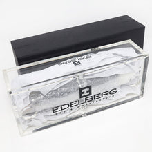Load image into Gallery viewer, The clear presentation box arranged with the outer black box on a white background. The Edelberg olgo is printed at the lid and sides

