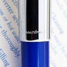 Load image into Gallery viewer, Close up to the bottom of the cap with the word Demonstrator engraved. 
