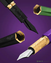 Load image into Gallery viewer, Close up to the Batman and Joker fountain pen nibs and caps on a purple background.
