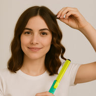 A young smiling woman while curling her hair.