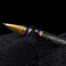 Load image into Gallery viewer, Close up to the rollerball pen grip section resting on black sand. 
