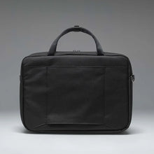 Load image into Gallery viewer, Back panel view of the black Gibson bag on a gray gradient background.
