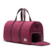 Load image into Gallery viewer, Angled front view of the duffle bag with the side shoe compartment unzipped. 
