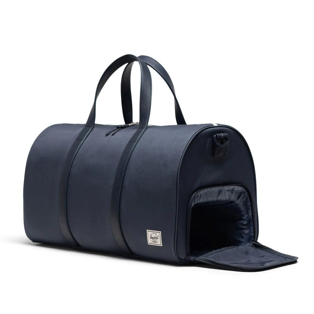 Front angled view of the duffle bag with the zipper compartment closed. 