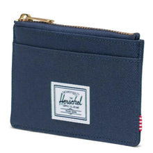 Load image into Gallery viewer, Angled view of the navy blue wallet with Herschel logo tag at at the front.
