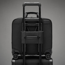 Load image into Gallery viewer, Back panel view of the black spinner brief. Its interlocking handle is attaching it to the extended handle on a suitcase. 
