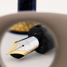 Load image into Gallery viewer, Close-up of a fountain pen's nib through a magnifying lens on a white background
