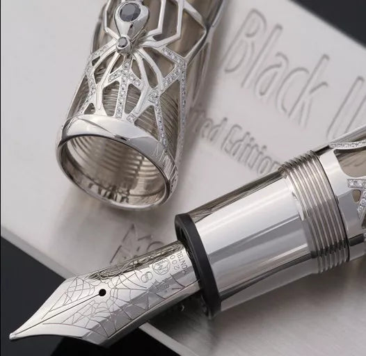 Close up to the nib and cap of the Black Widow pen. They are made of solid gold. The nib has an engraving with decorations of an elaborate spiderweb, the number 4810, the Montblanc logo