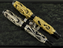 Load image into Gallery viewer, The Montegrappa 1995 Dragon fountain pens, capped, in gold and silver overlay, featuring intricate dragon engravings on black marbled celluloid bodies, displayed on a dark background.
