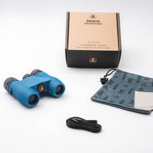 Load image into Gallery viewer, The blue binoculars arranged with the box, fabric pouch, strap and microfiber fabric. 
