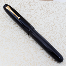 Load image into Gallery viewer, The fountain pen with the cap on, set on the outer box.
