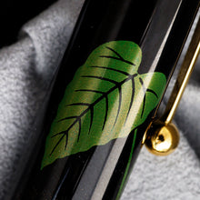 Load image into Gallery viewer, Close up to the green leaf on the cap.
