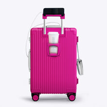 Load image into Gallery viewer, Back panel view of the hot pink suitcase showing a phone held by the telescopic handle and a hot drink in the cup holder.
