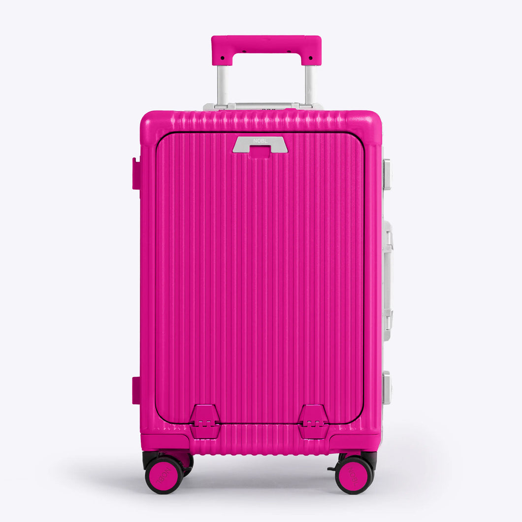 Front panel view of the hot pink suitcase. The telescopic handle is partly extended. 