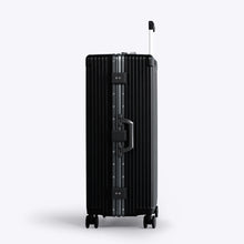 Load image into Gallery viewer, Side panel view of the black suitcase. A grab handle is available and two TSA approved three-digit combination locks. 
