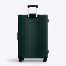 Load image into Gallery viewer, Back panel view of the green suitcase with silver colored accents. The telescopic handle is extended.
