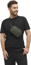 Load image into Gallery viewer, A young man carrying the sling bag across his sternum.
