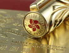 Load image into Gallery viewer, Top of the cap with a red emblem and text.
