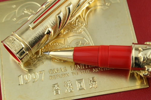 Gold and red pen on a gold plaque with '1997' and 'OMAS' text