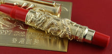 Load image into Gallery viewer, Gold and red pen with intricate design on a red background.
