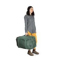 Load image into Gallery viewer, A young woman holding the green koseret pack by the side handle. 
