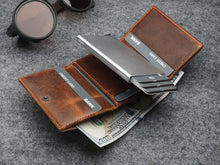 Load image into Gallery viewer, Interior view of the wallet with credit cards and cash arranged in the compartments. 
