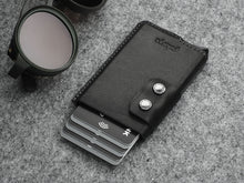 Load image into Gallery viewer, Angled front view of the black wallet with pularys embossing. Six credit cars peek from the top. 
