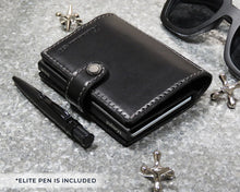 Load image into Gallery viewer, Angled view of the black wallet arranged with a pen, sunglasses and jacks toys.
