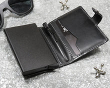 Load image into Gallery viewer, Interior view of the black wallet arranged with glasses and jacks toys.
